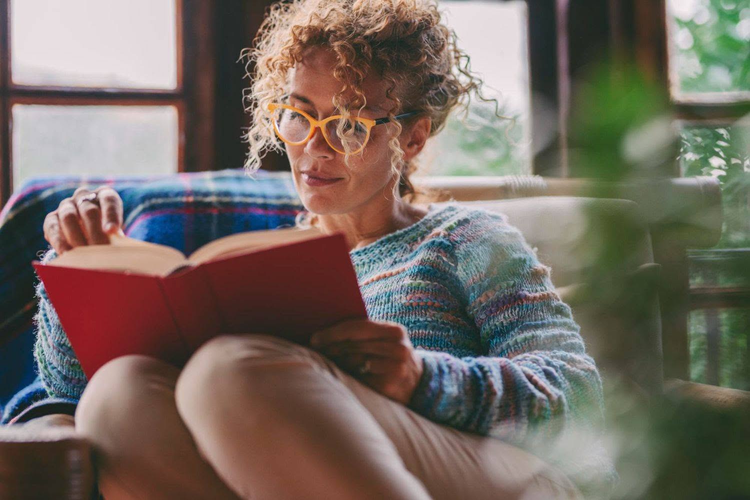 woman at home sitting and reading a book