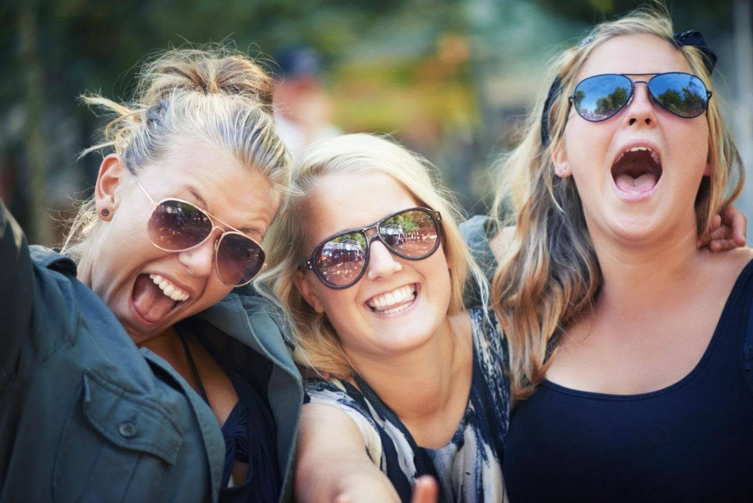 three happy women wearing sunglasses