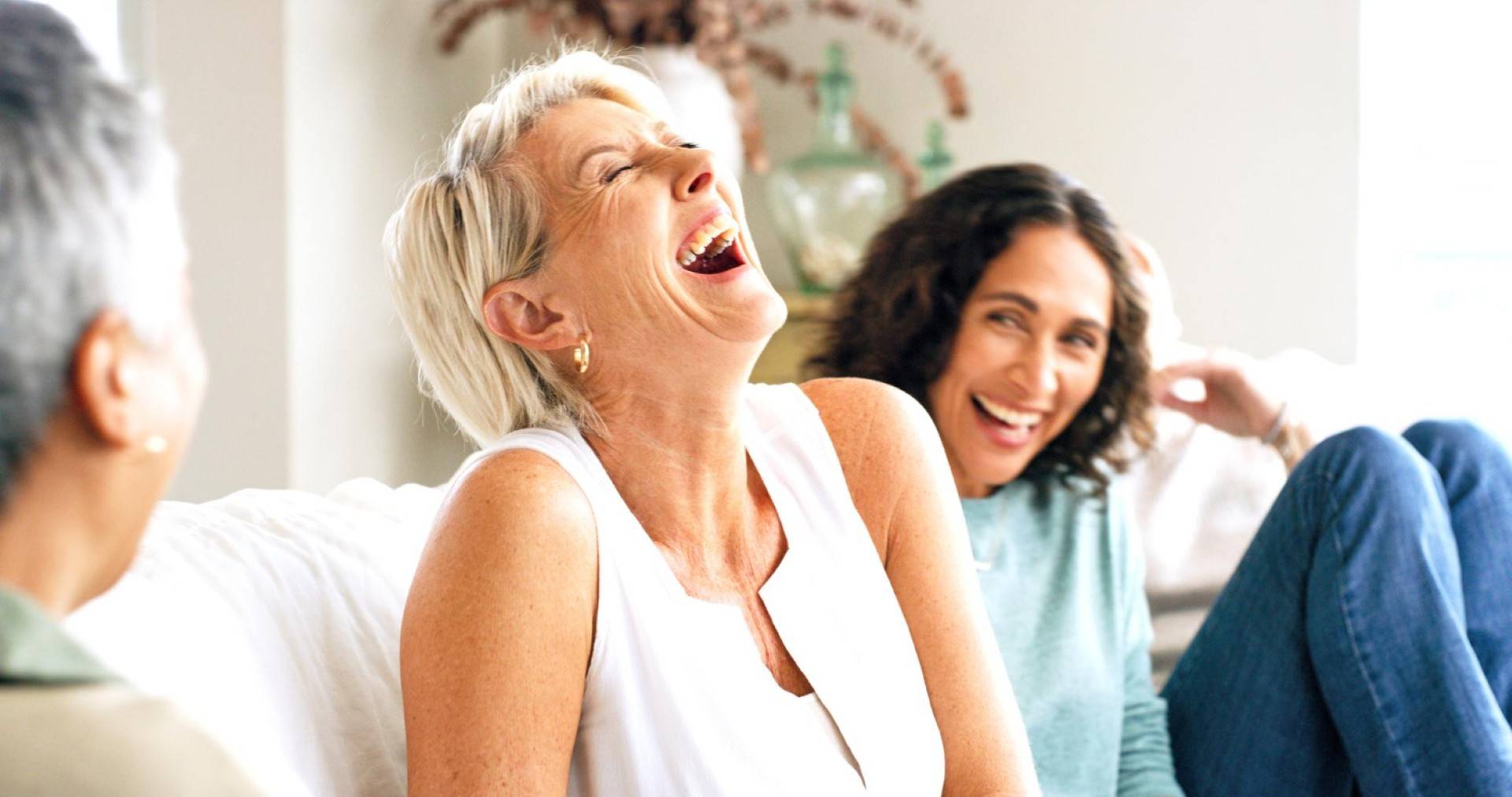laughing friends and mature woman on couch (large)